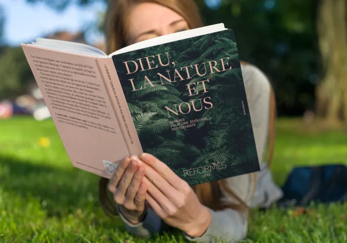 Le mook « Dieu, la nature et nous, Repères pour une écologie protestante» lu dans un pré. Photomontage (Eh oui, notre mook est en cours de fabrication)
