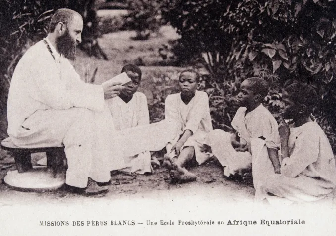 Missionnaire en Afrique : un membre de la société missionnaire des Pères Blancs enseignant à des enfants dans une école d'Afrique équatoriale. Carte postale des années 1930 ©Collection Sirot-Angel/leemage © Wikimedia Commons