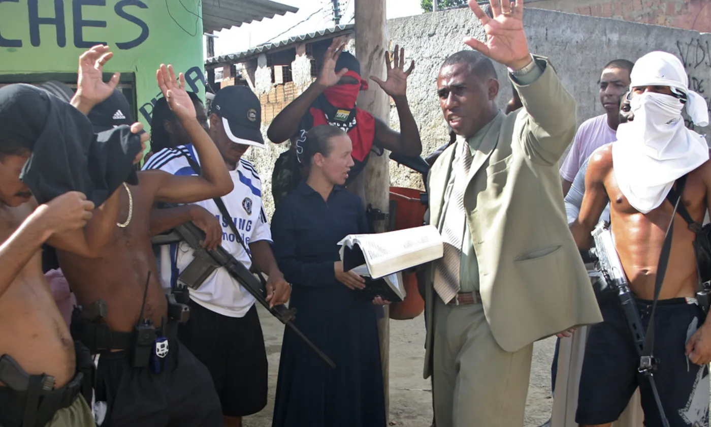 Sur cette photo prise le 31 mars 2009, le pasteur Andre Assis, au centre, prie avec des trafiquants de drogue présumés dans un bidonville de Rio de Janeiro. Keystone